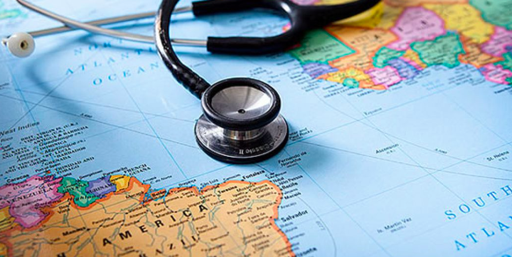 Black stethoscope laying on a map of the world
